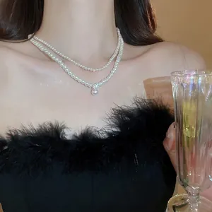 Elegant layered pearl necklace with zircon pendant on a model in evening attire