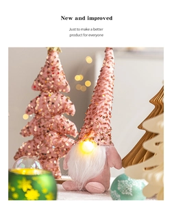 Nahaufnahme eines rosa Pailletten-Weihnachtswichtels mit leuchtender Nase und Deko-Baum