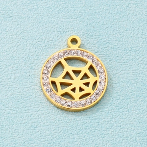 Detailed view of a gold spider web pendant with clear crystals on a blue surface
