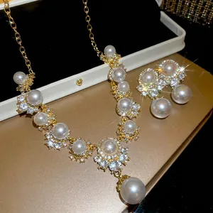Elegant gold necklace and pearl earrings set with sparkling crystal accents for women