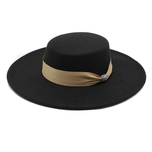 Close-up of black flat top wool hat with satin ribbon and sparkling rhinestone buckle