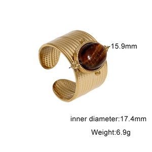 Detail view of gold stainless steel ring with tiger eye stone and striped texture details