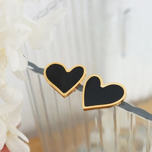 Elegant 18K gold-plated heart earrings with black acrylic inlay on a glass edge