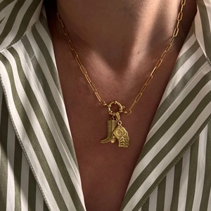 Close-up of 18k gold paperclip chain necklace with cowboy boot and poker card pendants