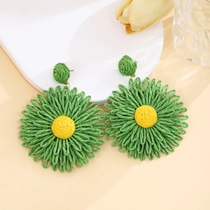 Close-up of handmade woven sunflower earrings in vibrant green and yellow raffia style