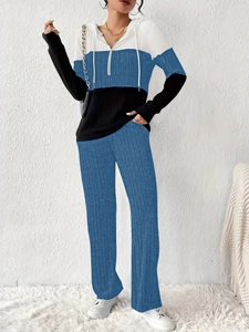 Detail of color-block hooded sweatshirt and pants set with white, blue, and black panels