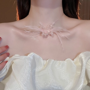 Close-up of pink feather butterfly necklace with crystal beads on model neck