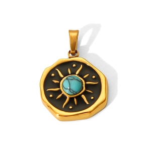 Detail of vintage sunburst pendant with green turquoise stone on black enamel background