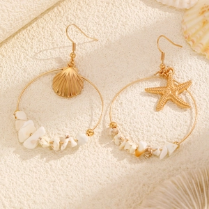 Detail of asymmetrical ocean earrings with starfish, seashells and white stone beads