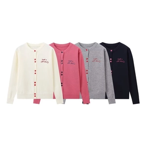 Detail of embroidered 'have a nice day' text and smiley face on knit cardigans