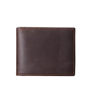Close-up of vintage dark brown leather wallet showing fine stitching and natural grain
