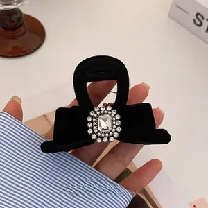 Close-up of black velvet bow headband with sparkling rhinestone crystal embellishment