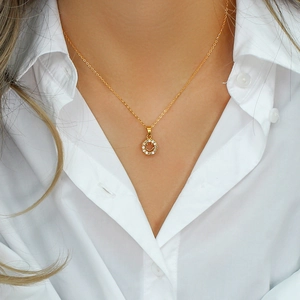 Close-up of a smiling face pendant necklace in 18K gold plated steel on a model