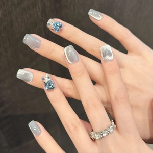 Eisblaue Katzenaugen-Kunstnägel mit blauen Herzsteinen und silbernem Blumenring