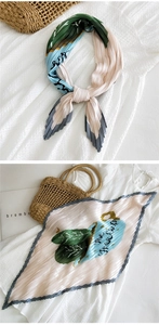 Dettaglio di un foulard in seta a pieghe con stampa floreale rosa e bordi a contrasto