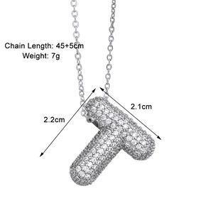 Macro shot of silver letter T pendant with zircon inlay showing dimensions and metal luster