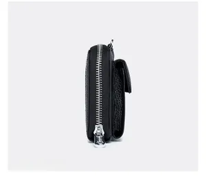 Detailed side view of black pebble leather crossbody bag showing silver zipper and stitching