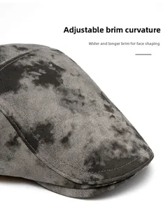 Detail of adjustable curved brim and wide silhouette on grey tie-dye newsboy cap