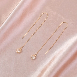 Elegant rose gold threader earrings with zircon star charms on luxury silk fabric
