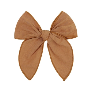 Close-up of brown linen bow hair clip showing woven texture and detailed stitching