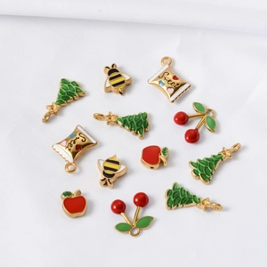 Detailed flat lay of colorful Christmas themed enamel charms in gold stainless steel