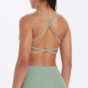 Détail du soutien-gorge de sport vert clair à fines bretelles croisées et legging de yoga