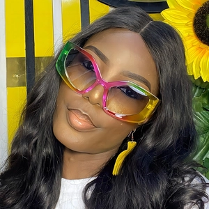 Close-up of rainbow gradient oversized butterfly sunglasses worn on a female model