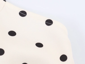 Détail macro du tissu beige à pois noirs avec couture de bordure de haute qualité