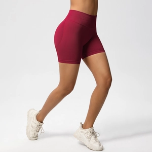 Detail of burgundy seamless high waist workout shorts with peach lift effect on model