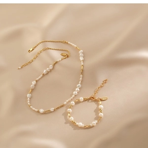 Baroque freshwater pearl and gold bead necklace and bracelet set on beige silk background