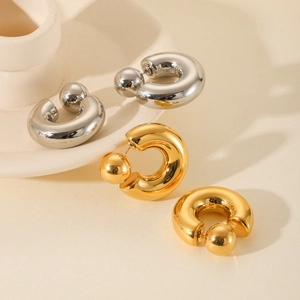 Detail of chunky C-shape hoop earrings in polished gold and silver with ball backings