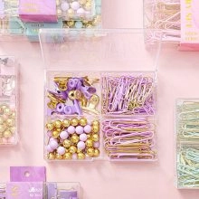 Purple and gold office stationery set with binder clips and pins in a clear 4-grid box