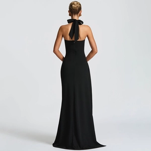 Elegant backless black maxi dress with a halter neck and large bow detail in a studio setting