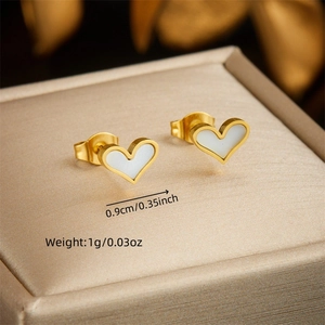 Elegant gold-plated heart stud earrings with white inlay on a beige jewelry display box