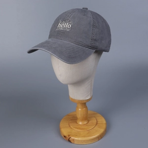 Detalle de gorra de algodón lavado gris con bordado hello de estilo minimalista