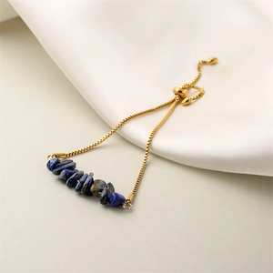 Macro detail of adjustable golden box chain with irregular blue natural stone beads on silk