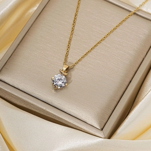 Élégant collier doré avec pendentif en zircon rond présenté dans un coffret de luxe