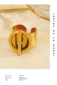 Close-up of golden wide-band open ring featuring a stylish geometric OT toggle clasp