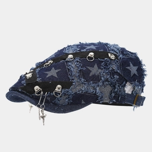 Detail of dark blue denim beret with metal rings and star patterns for street style