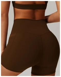 Detail showing high-waist fitness shorts with side pockets and V-shape back stitching
