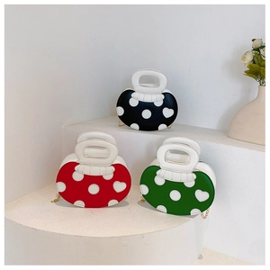 Three mushroom shaped handbags in red green and black with white polka dots and heart patterns