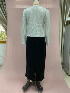 Detail of silver sequined cropped jacket paired with a black side-slit midi skirt