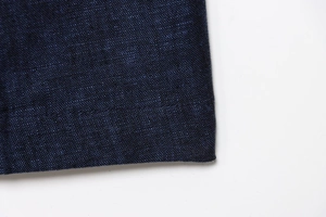 Nahaufnahme der tiefblauen Leinenmischung des Denim-Sets aus Weste und weiter Hose