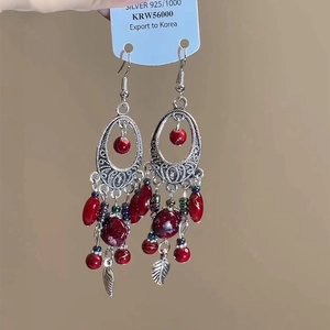 Makro-Detail böhmischer roter Quastenohrringe mit Silber 925 Stecker und Blumenanhängern