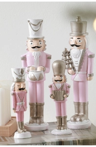 Pink Nutcracker soldier set on decorative books featuring drum and Christmas tree motifs