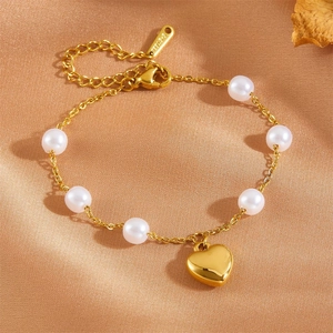 Vue macro d'un bracelet pendentif cœur 18K avec perles blanches sur tissu satin