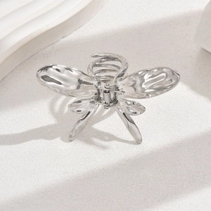 Detailed view of a silver liquid metal butterfly hair claw clip with a glossy finish