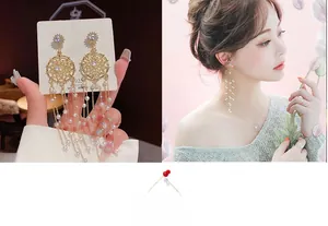 Detail of dreamcatcher tassel earrings with gold finish, pearls and star-shaped zircons