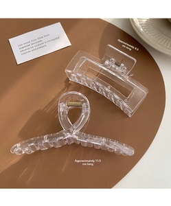 Close-up of clear 8.5cm and 11.5cm acrylic hair claws with gold springs and sleek designs