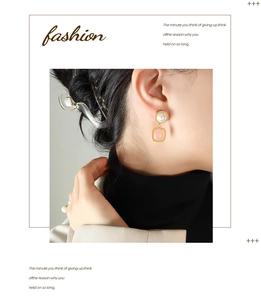 Close-up of elegant pink stone and pearl drop earrings worn by model in white blazer